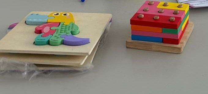 Rompecabezas de madera y juego de encastre sobre un escritorio, usados en la atención infantil